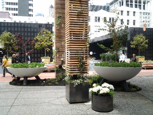 Red dahlias and rose-filled planters at Britomart